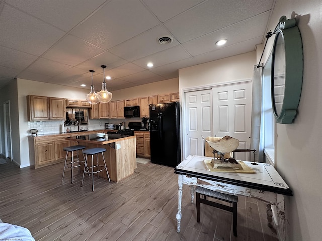 717 Lakeview Dr, Horner, WV 26372 - kitchen featuring black appliances, a center island, wood finished floors, a drop ceiling, and a kitchen bar