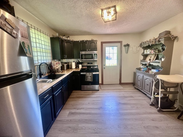 1829 Crooked Run Rd, Clarksburg, WV 26301 - kitchen featuring appliances with stainless steel finishes, a sink, light wood-style flooring, a textured ceiling, and light countertops