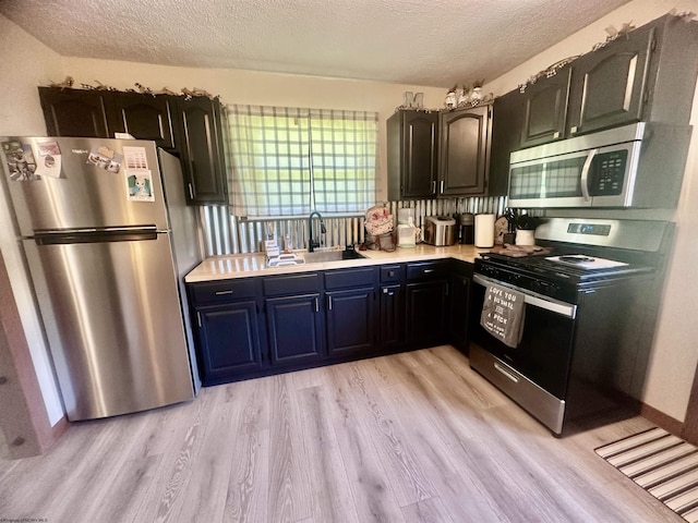 1829 Crooked Run Rd, Clarksburg, WV 26301 - kitchen with appliances with stainless steel finishes, a sink, light countertops, light wood finished floors, and a textured ceiling