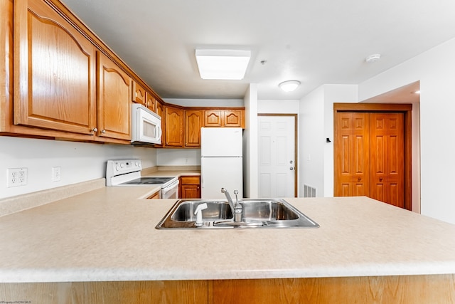 233 Creekside Dr Unit 3, Morgantown, WV 26508 - kitchen featuring white appliances, a sink, light countertops, brown cabinetry, and a peninsula