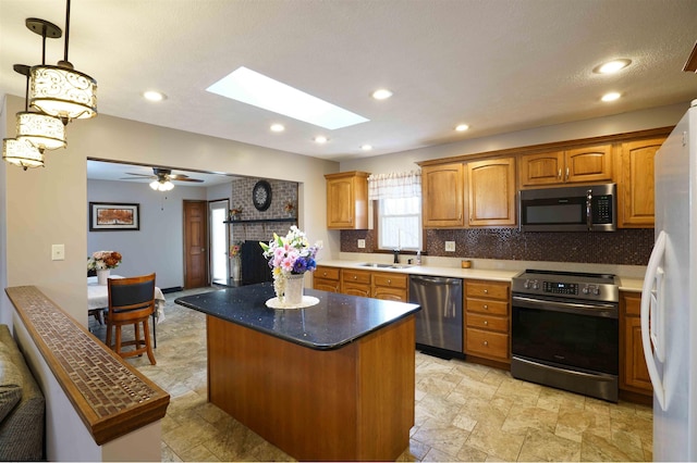 213 Forest Dr, Bridgeport, WV 26330 - kitchen featuring stainless steel appliances, backsplash, a kitchen island, brown cabinetry, and light stone finish floors