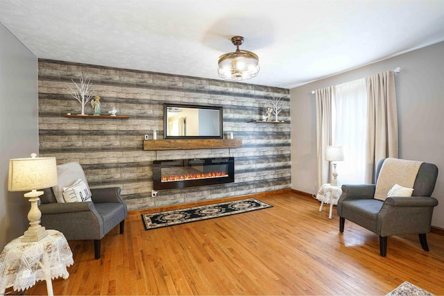213 Forest Dr, Bridgeport, WV 26330 - living room featuring a glass covered fireplace, an accent wall, baseboards, and wood finished floors
