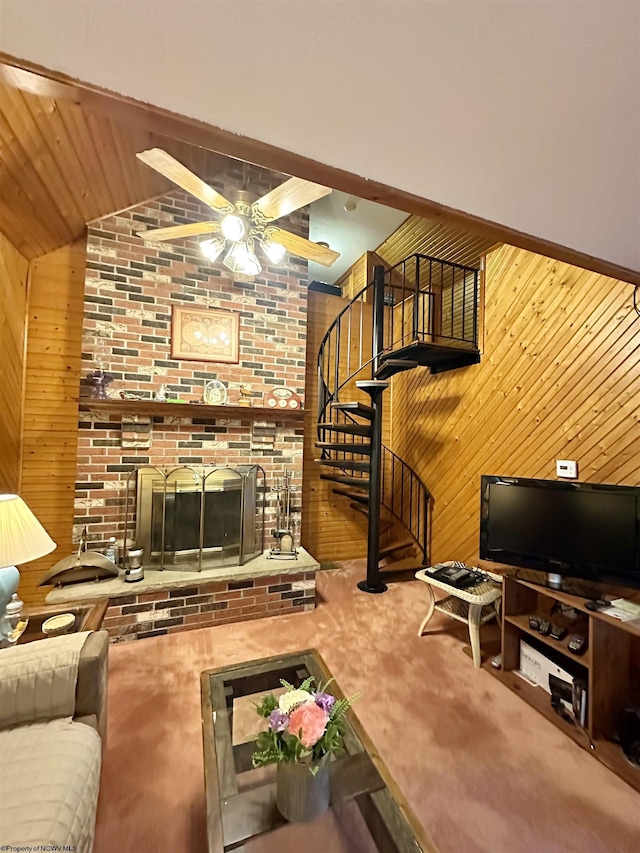 1322 Crystal Lake Rd, West Union, WV 26456 - carpeted living area with a fireplace, wooden walls, ceiling fan, stairway, and vaulted ceiling