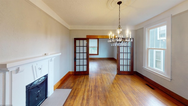 505 State St, Fairmont, WV 26554 - unfurnished dining area with french doors, a chandelier, wood finished floors, and baseboards