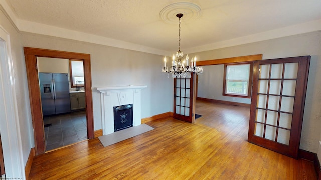 505 State St, Fairmont, WV 26554 - unfurnished living room featuring wood finished floors, a chandelier, a fireplace with flush hearth, and baseboards