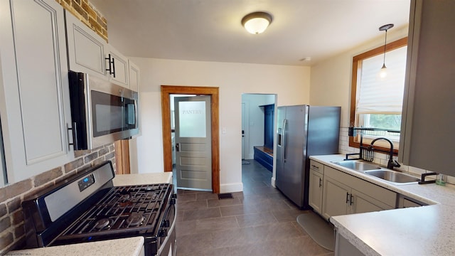 505 State St, Fairmont, WV 26554 - kitchen with appliances with stainless steel finishes, decorative backsplash, light countertops, a sink, and pendant lighting