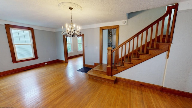 505 State St, Fairmont, WV 26554 - staircase with a chandelier, baseboards, wood finished floors, and a textured ceiling