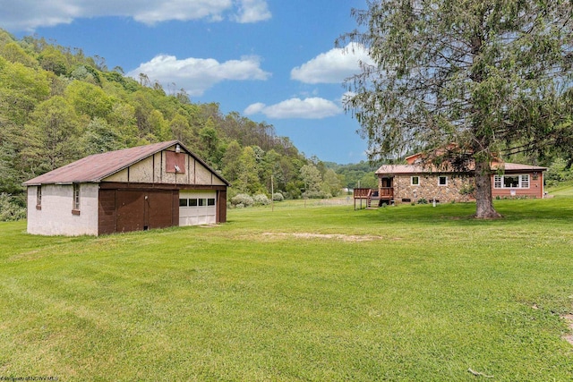 595 States Fork Rd, Metz, WV 26585 - view of green lawn featuring a garage, an outbuilding, and a wooded view