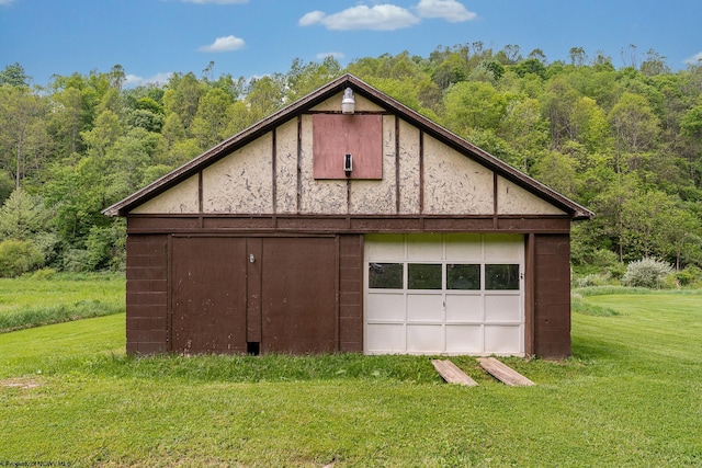 595 States Fork Rd, Metz, WV 26585 - view of side of home with an outbuilding, a lawn, a wooded view, and a detached garage