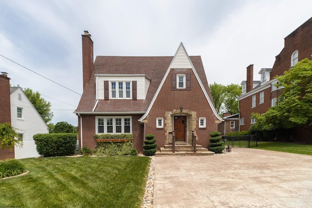 328 W Philadelphia Ave, Bridgeport, WV 26330 - english style home featuring a chimney, a front lawn, and brick siding