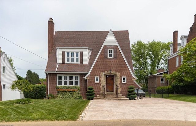328 W Philadelphia Ave, Bridgeport, WV 26330 - tudor home featuring brick siding, roof with shingles, and a chimney