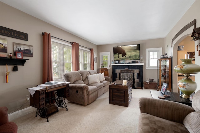 328 W Philadelphia Ave, Bridgeport, WV 26330 - living area with light colored carpet, arched walkways, a tiled fireplace, and baseboards