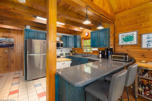 1 Ginger Ct, Terra Alta, WV 26764 - kitchen with appliances with stainless steel finishes, blue cabinetry, wooden walls, wooden ceiling with exposed beams, and a peninsula
