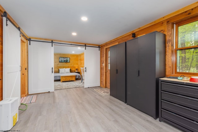 1 Ginger Ct, Terra Alta, WV 26764 - unfurnished bedroom with a barn door, wood walls, light wood-style floors, recessed lighting, and multiple windows