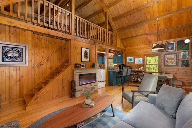 1 Ginger Ct, Terra Alta, WV 26764 - living area with wooden walls, light wood-style flooring, high vaulted ceiling, stairway, and wood ceiling with exposed beams