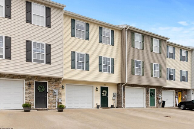 112 Eagle Dr, Maidsville, WV 26541 - townhome / multi-family property with an attached garage, driveway, and stone siding
