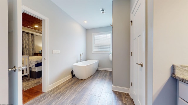 123 Sadie Ln, Morgantown, WV 26508 - bathroom with a freestanding tub, connected bathroom, wood finished floors, vanity, and recessed lighting