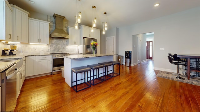 123 Sadie Ln, Morgantown, WV 26508 - kitchen with custom range hood, stainless steel appliances, a center island, tasteful backsplash, and a kitchen breakfast bar