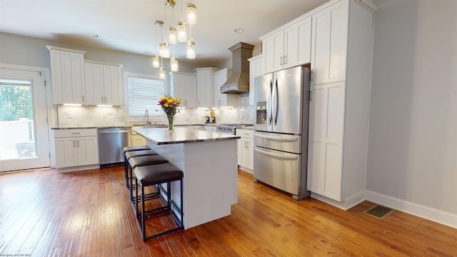 123 Sadie Ln, Morgantown, WV 26508 - kitchen featuring appliances with stainless steel finishes, premium range hood, healthy amount of natural light, a kitchen bar, and recessed lighting