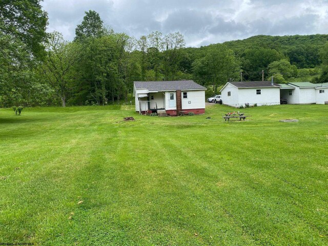 21434 Seneca Trl, Valley Head, WV 26294 - view of grassy yard with a view of trees and an outbuilding