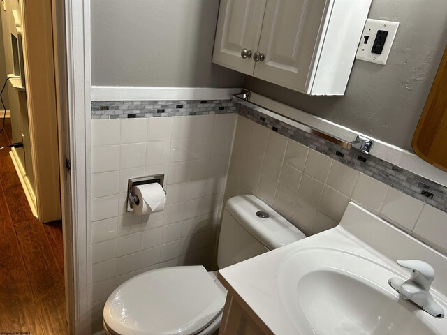 2605 E Main St, Bridgeport, WV 26330 - half bathroom featuring tile walls, toilet, vanity, wood finished floors, and wainscoting