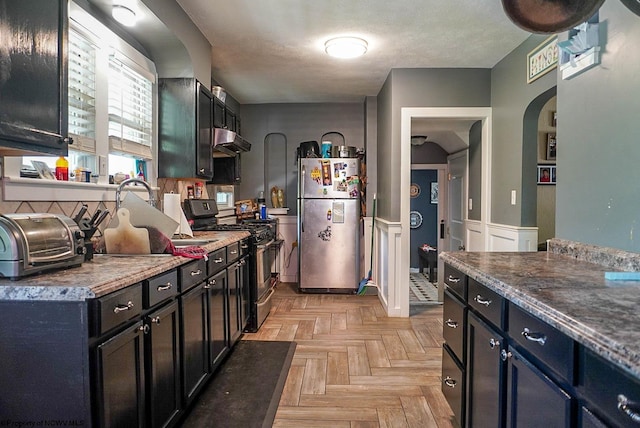 1917 Pleasant Valley Rd, Fairmont, WV 26554 - kitchen with appliances with stainless steel finishes, under cabinet range hood, arched walkways, a wainscoted wall, and dark cabinets