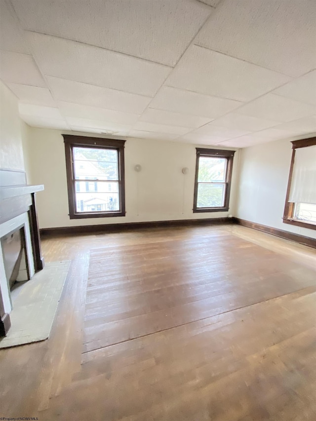 229-231 Meigs Ave Unit 2, Clarksburg, WV 26301 - unfurnished living room featuring a fireplace with raised hearth, wood finished floors, baseboards, and a paneled ceiling