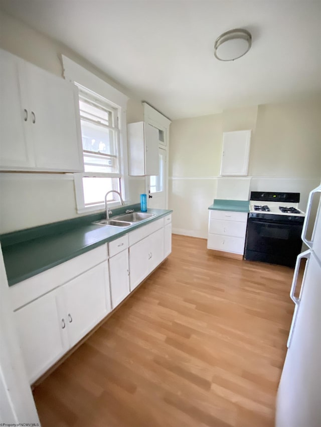 229-231 Meigs Ave Unit 2, Clarksburg, WV 26301 - kitchen with range with gas stovetop, a sink, light wood-style flooring, and white cabinets