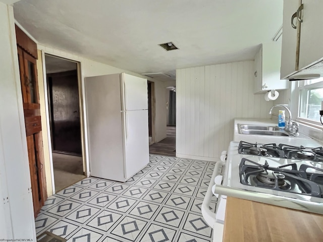 1501 Rose Ln, Fairmont, WV 26554 - kitchen featuring white appliances, a sink, wood walls, and light countertops