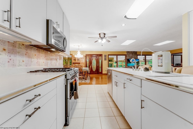 237 Highland Ave, Grafton, WV 26354 - kitchen featuring stainless steel appliances, light countertops, white cabinetry, backsplash, and a ceiling fan