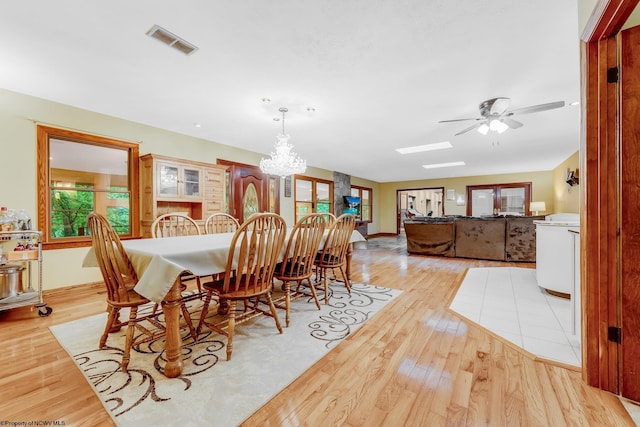 237 Highland Ave, Grafton, WV 26354 - dining room featuring light wood-type flooring, a chandelier, ceiling fan, a skylight, and baseboards