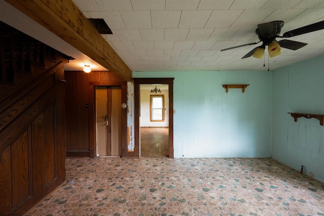 248 Casteel Rd, Terra Alta, WV 26764 - spare room with ceiling fan, wood walls, and stairway