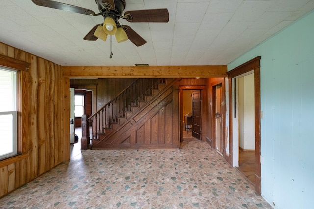 248 Casteel Rd, Terra Alta, WV 26764 - unfurnished living room with wooden walls, stairs, and ceiling fan