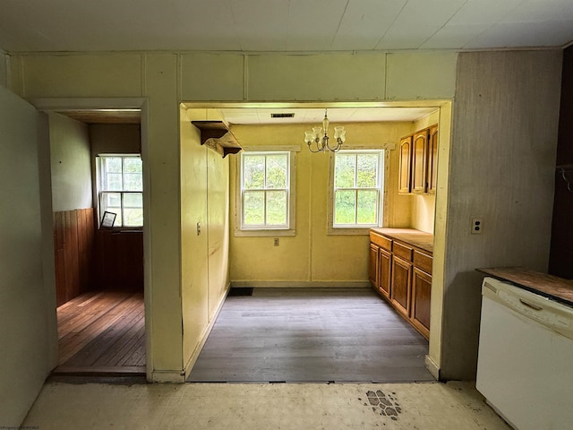 248 Casteel Rd, Terra Alta, WV 26764 - kitchen featuring white dishwasher, a chandelier, healthy amount of natural light, brown cabinets, and wooden walls