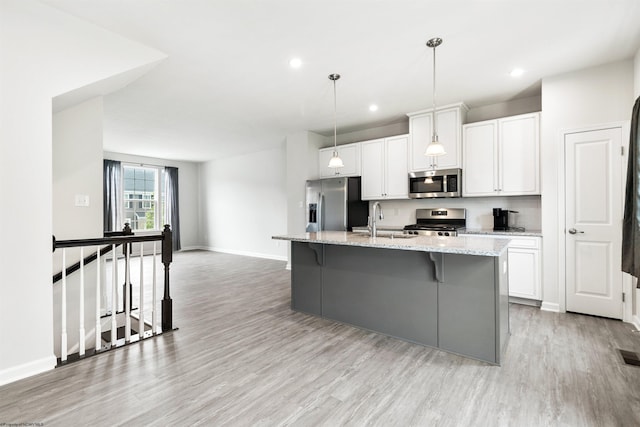 233 Stonehurst Dr, Morgantown, WV 26501 - kitchen featuring appliances with stainless steel finishes, a sink, a kitchen island with sink, white cabinetry, and baseboards
