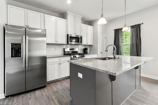 233 Stonehurst Dr, Morgantown, WV 26501 - kitchen featuring stainless steel appliances, a sink, wood finished floors, an island with sink, and tasteful backsplash