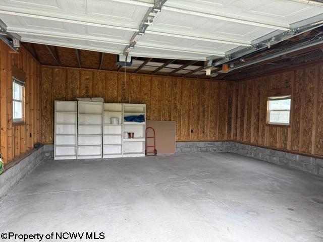 227 Wamsley Way, Valley Bend, WV 26293 - garage featuring wood walls and a garage door opener