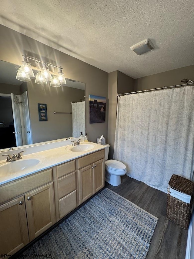 203 Tarbert Ct, Morgantown, WV 26508 - bathroom with wood finished floors, double vanity, toilet, and a textured ceiling