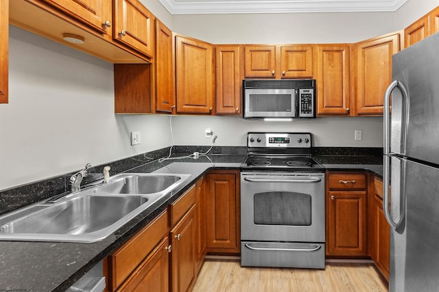 1318 Suncrest Vlg, Morgantown, WV 26505 - kitchen with appliances with stainless steel finishes, a sink, brown cabinetry, ornamental molding, and light wood-style flooring