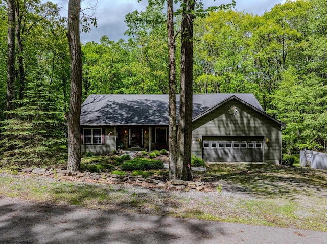 390 Aster Cir, Terra Alta, WV 26764 - view of front of home featuring driveway, covered porch, a garage, a wooded view, and roof with shingles