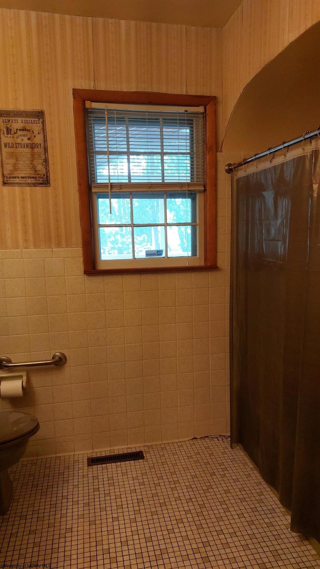 110 15th St, Elkins, WV 26241 - bathroom featuring toilet, tile patterned flooring, wallpapered walls, a shower with shower curtain, and tile walls