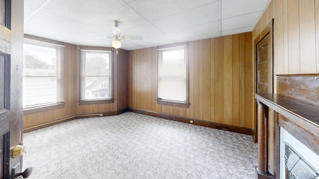 820 Field St, Fairmont, WV 26554 - empty room featuring baseboards, wood walls, carpet floors, a drop ceiling, and a ceiling fan
