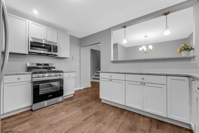 135 Celtic Dr, Clarksburg, WV 26301 - kitchen with appliances with stainless steel finishes, a chandelier, white cabinets, light wood-style flooring, and decorative light fixtures