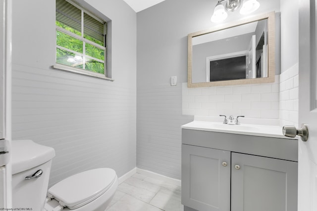 135 Celtic Dr, Clarksburg, WV 26301 - bathroom featuring toilet, vanity, marble look tiles, and wainscoting