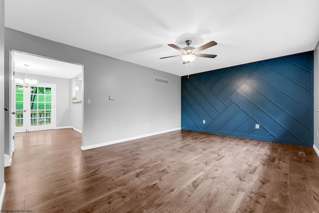 135 Celtic Dr, Clarksburg, WV 26301 - spare room with an accent wall, ceiling fan, wood finished floors, and a chandelier