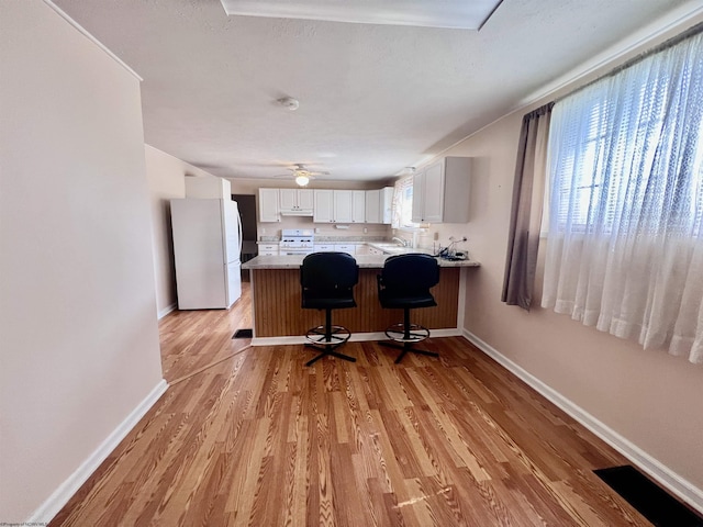 600 Wilson St, Elkins, WV 26241 - kitchen featuring white appliances, a peninsula, white cabinetry, and baseboards