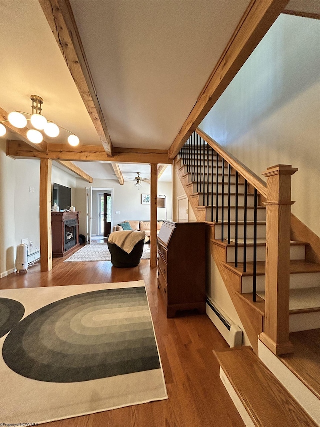 420 Fairfax Ave, Davis, WV 26260 - stairs featuring a baseboard radiator, wood finished floors, beamed ceiling, a ceiling fan, and a fireplace