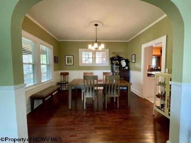5 Key St, Elkins, WV 26241 - dining space featuring dark wood-type flooring, healthy amount of natural light, a chandelier, crown molding, and wainscoting