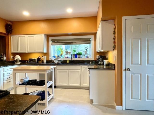 5 Key St, Elkins, WV 26241 - kitchen with a sink, white cabinets, dark countertops, light tile patterned flooring, and recessed lighting
