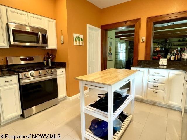5 Key St, Elkins, WV 26241 - kitchen with stainless steel appliances, white cabinets, and light tile patterned floors